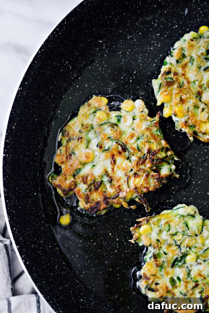 Crispy Zucchini Corn Fritters 13 Perfectly golden brown Zucchini Corn Fritters frying in the skillet