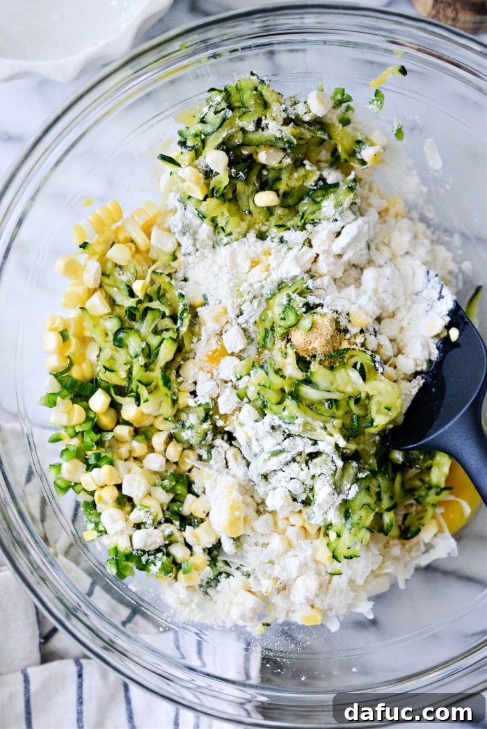 Crispy Zucchini Corn Fritters 9 A rubber spatula mixing the Zucchini Corn Fritter batter