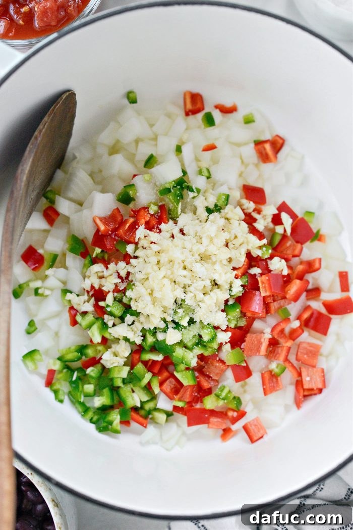 Adding oil, onion, peppers, and garlic with a pinch of salt to a pot for chili