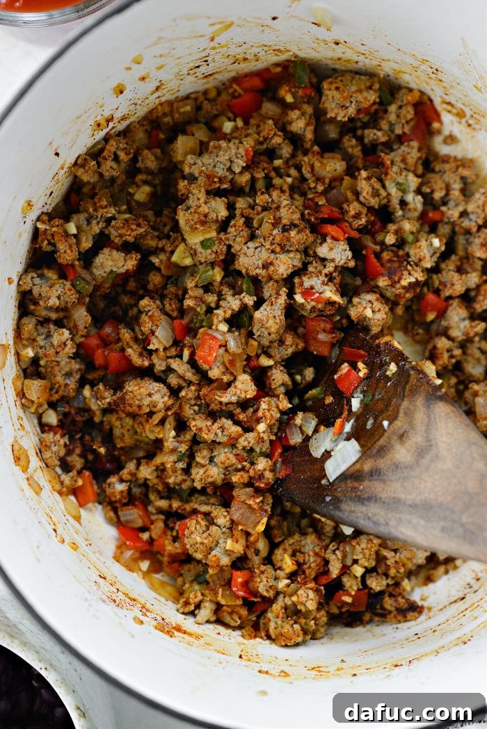 Adding tomatoes, sweet potatoes, and black beans to the pot