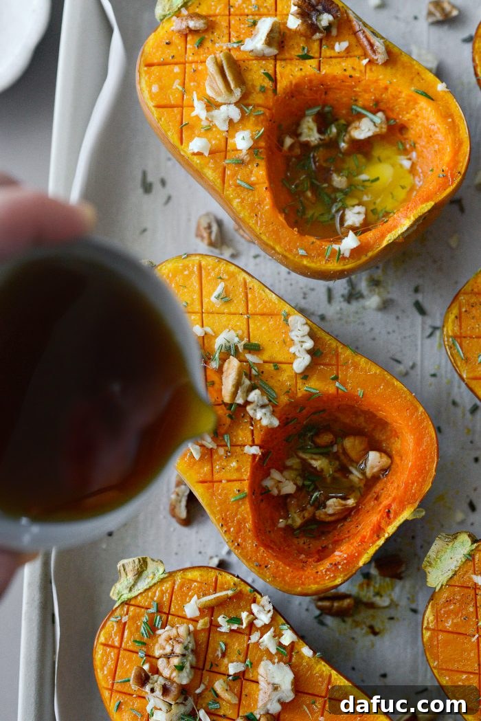 Drizzling pure maple syrup over seasoned honeynut squash halves.