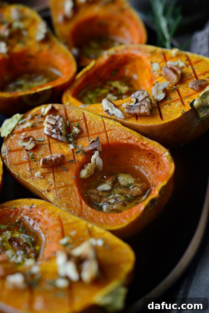 Roasted Honeynut Squash halves seasoned with pecans, rosemary, garlic, and maple syrup.