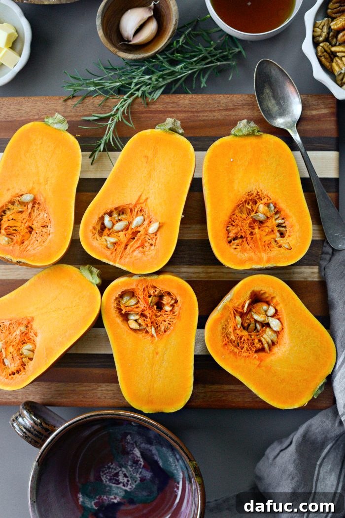 Cutting a honeynut squash in half vertically with a chef's knife.