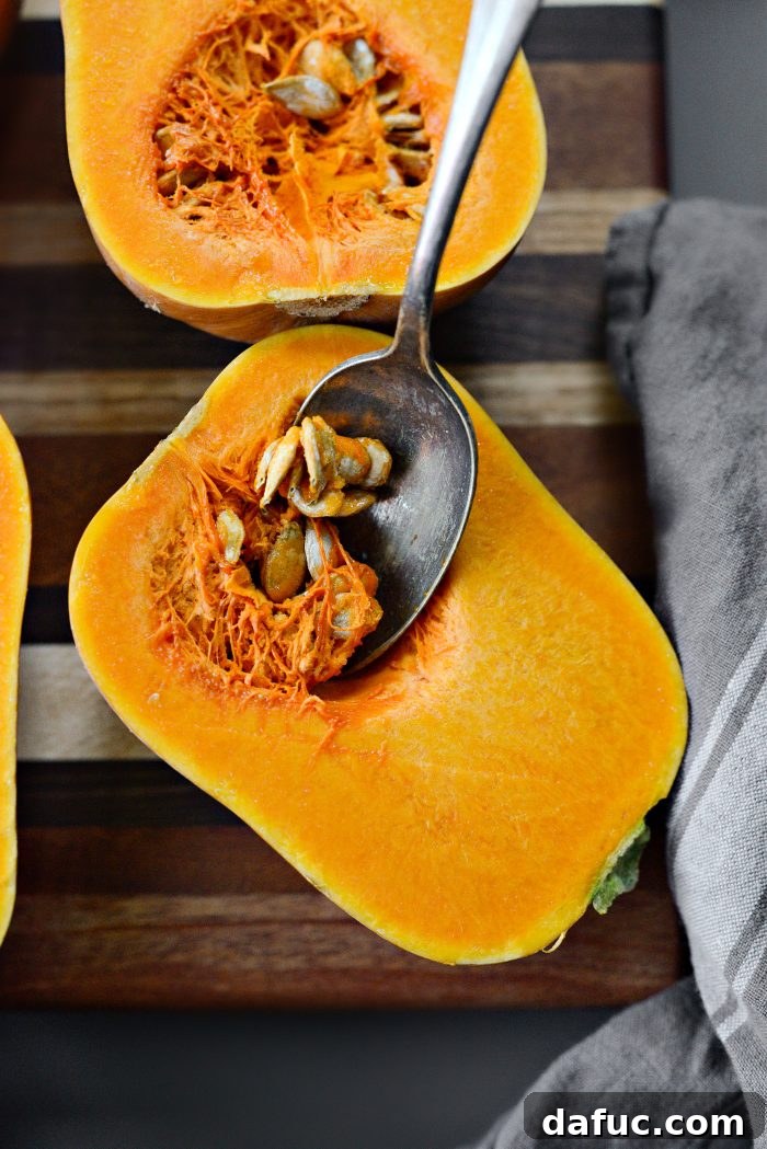 Scooping seeds and fibers from honeynut squash halves.