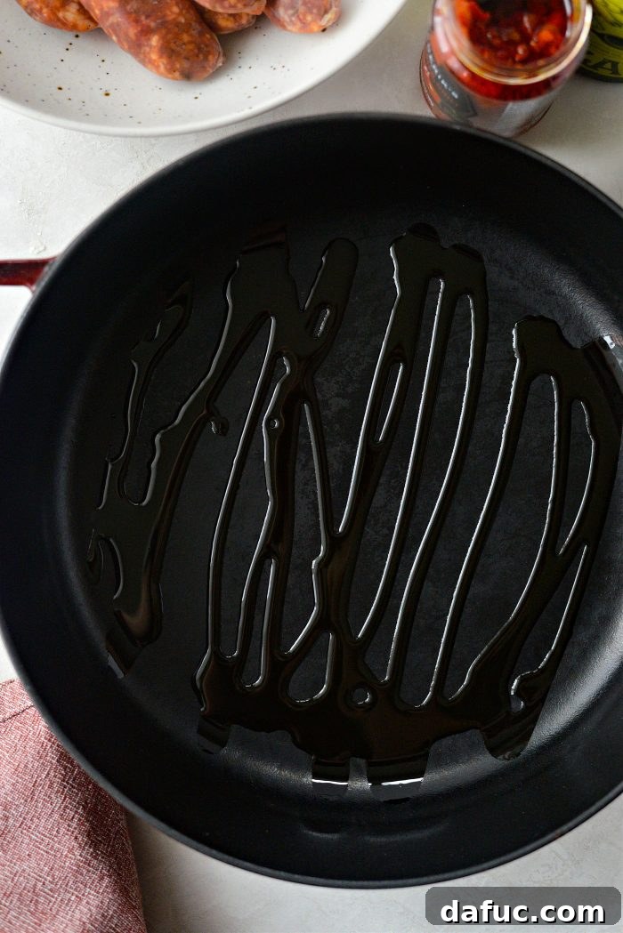 Olive oil shimmering in a hot 10-inch deep-sided skillet on the stovetop, ready for cooking vegetables.