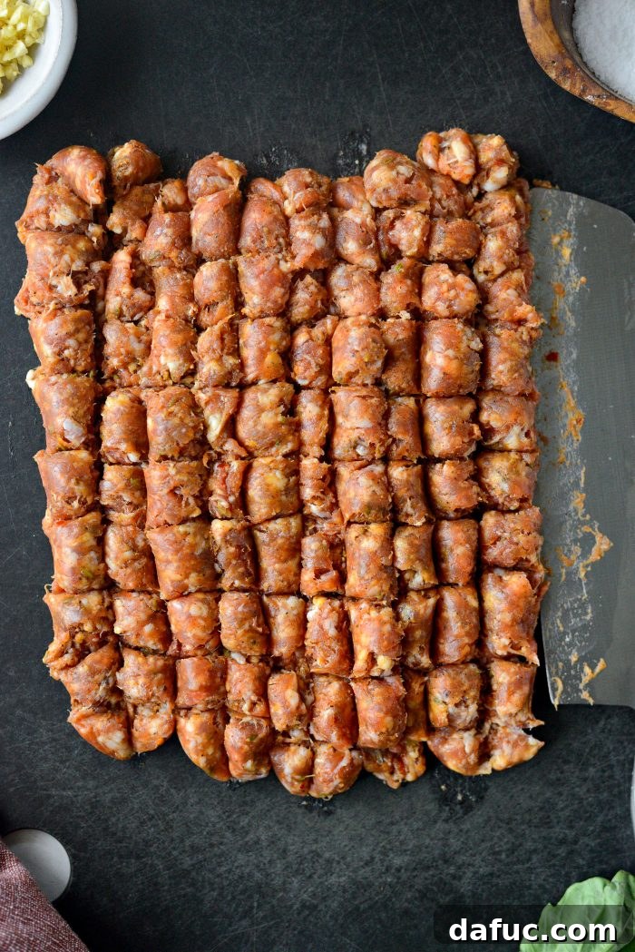 Coarsely chopped spicy Italian sausage meat on a cutting board, ready to be added to the skillet.
