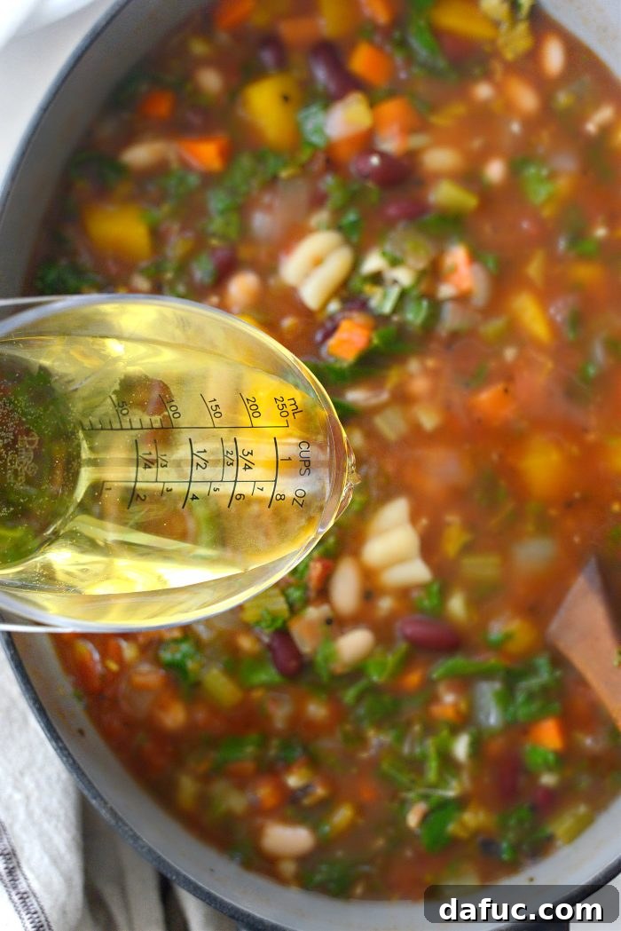 Golden Autumn Pumpkin Minestrone 17 Dry white wine being poured into the minestrone
