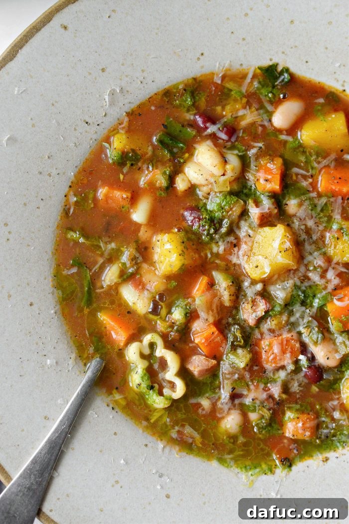 Golden Autumn Pumpkin Minestrone 23 Pumpkin Minestrone in a rustic bowl with a spoon