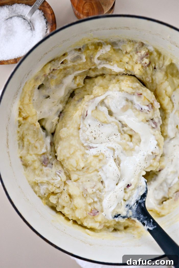 Velvet Garlic Potatoes 14 Mashed potatoes being stirred to combine all ingredients in the pot