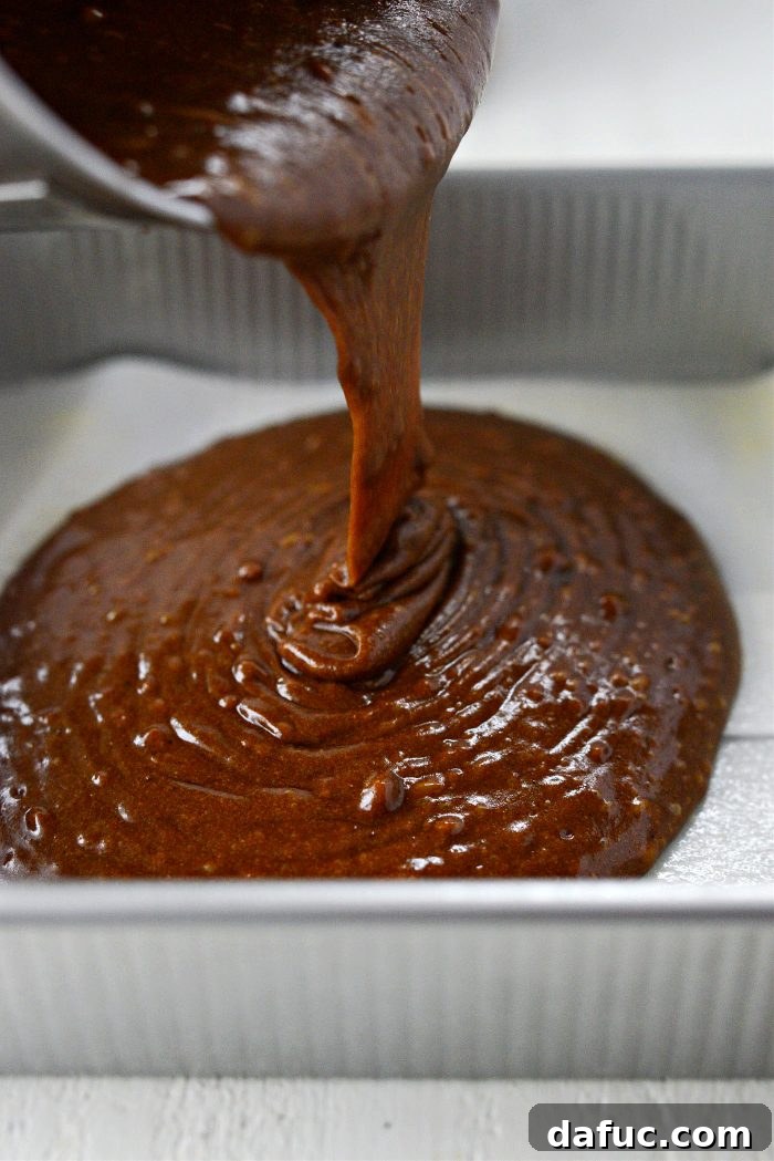 Pouring gingerbread cake batter into prepared pan
