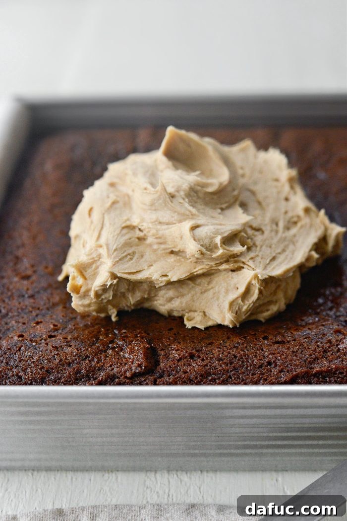 Applying brown sugar frosting to cooled gingerbread cake