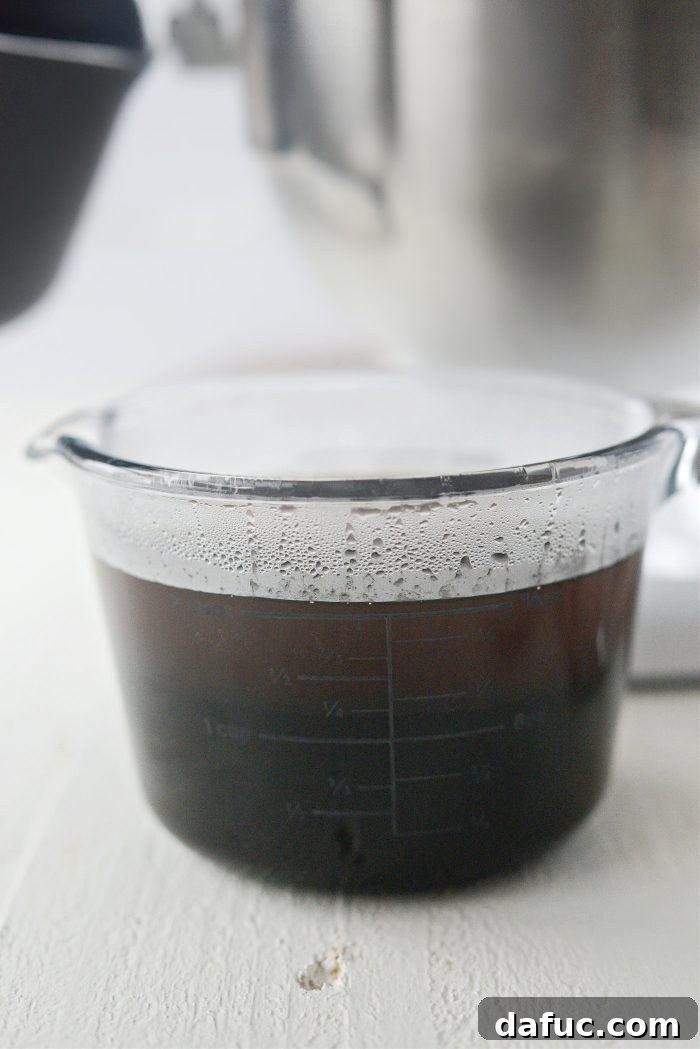Adding boiling water to molasses in a measuring cup