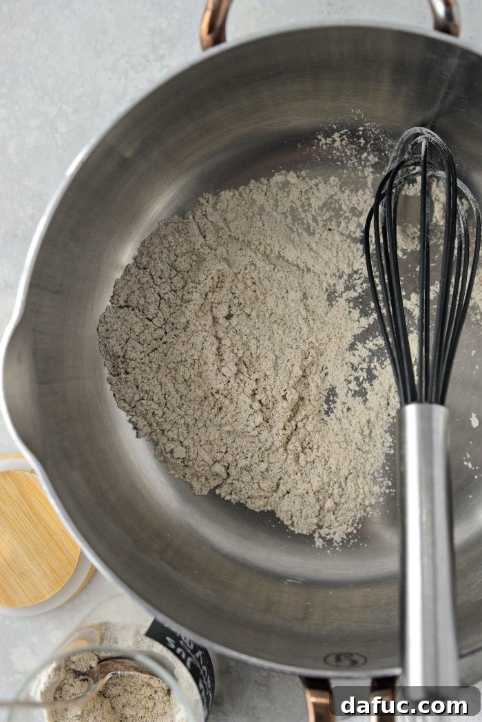 Measuring au jus gravy mix into a sauce pan