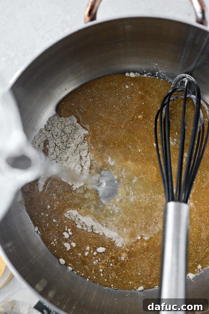 Adding water to au jus gravy mix in a saucepan