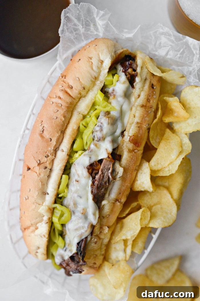 A perfectly assembled Mississippi Pot Roast Sandwich, sliced in half, showing all the layers, ready to be served.