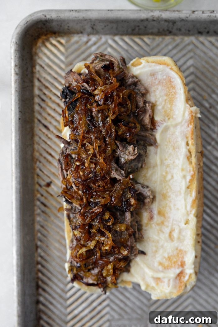 Crispy fried onions layered on top of Mississippi pot roast on a sandwich bun.