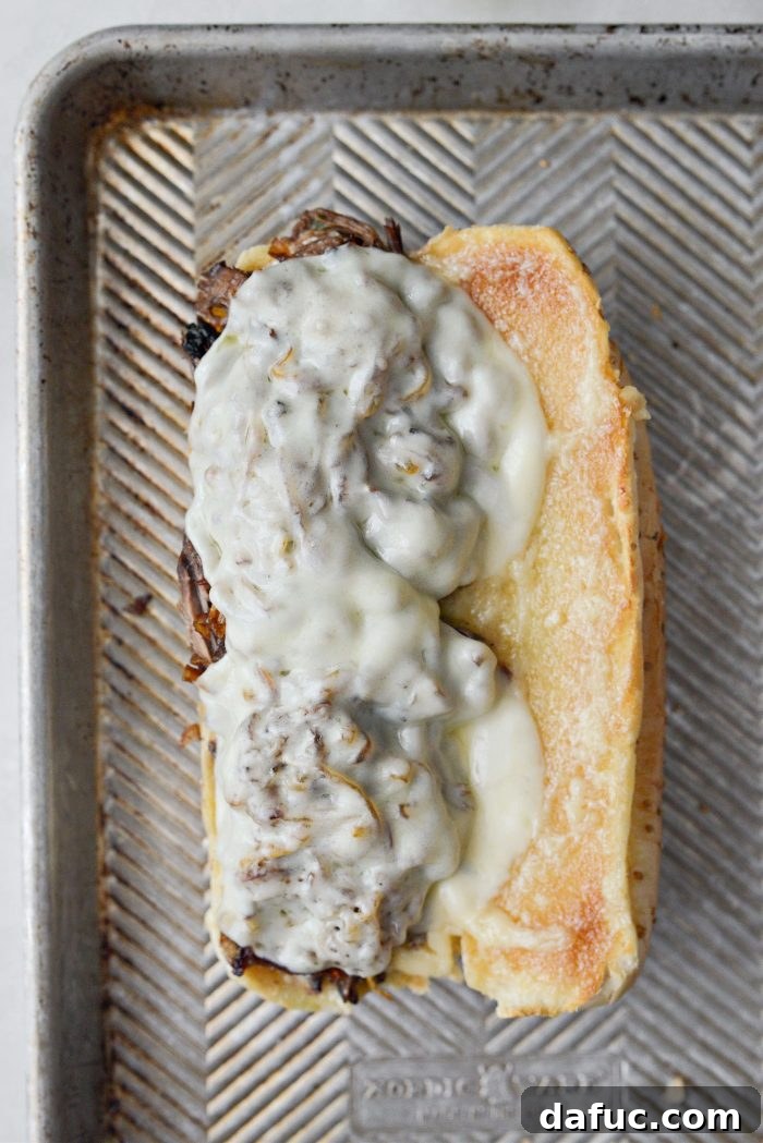 Mississippi Pot Roast Sandwich under the broiler, with provolone cheese melting and bubbling.