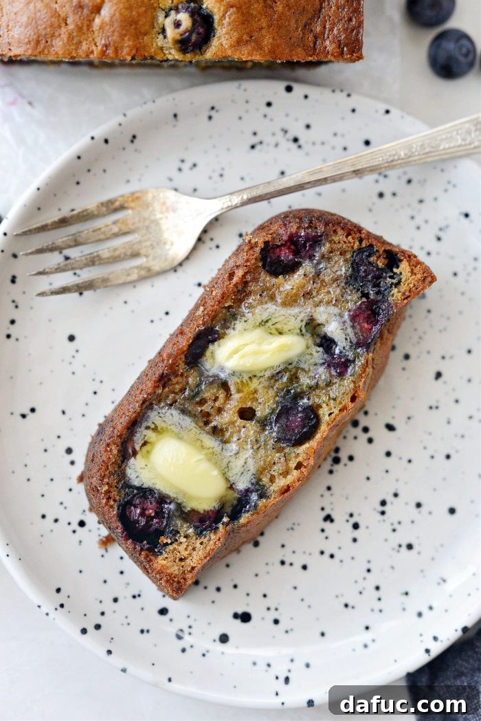 Two slices of Blueberry Banana Bread on a white plate, ready to eat