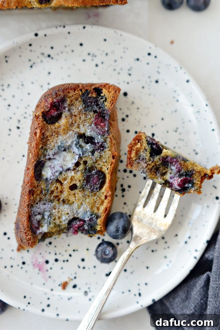 A final beautiful shot of a sliced Blueberry Banana Bread on a serving board