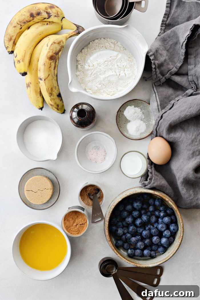 Various ingredients for Blueberry Banana Bread laid out on a surface