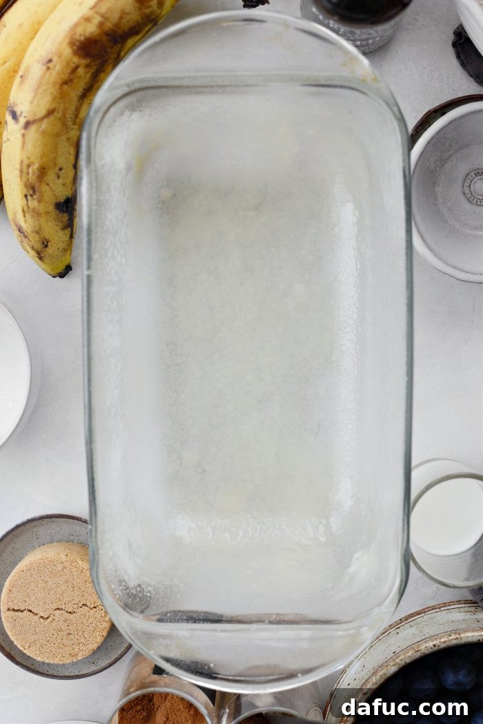 Loaf pan being prepared with nonstick spray and flour