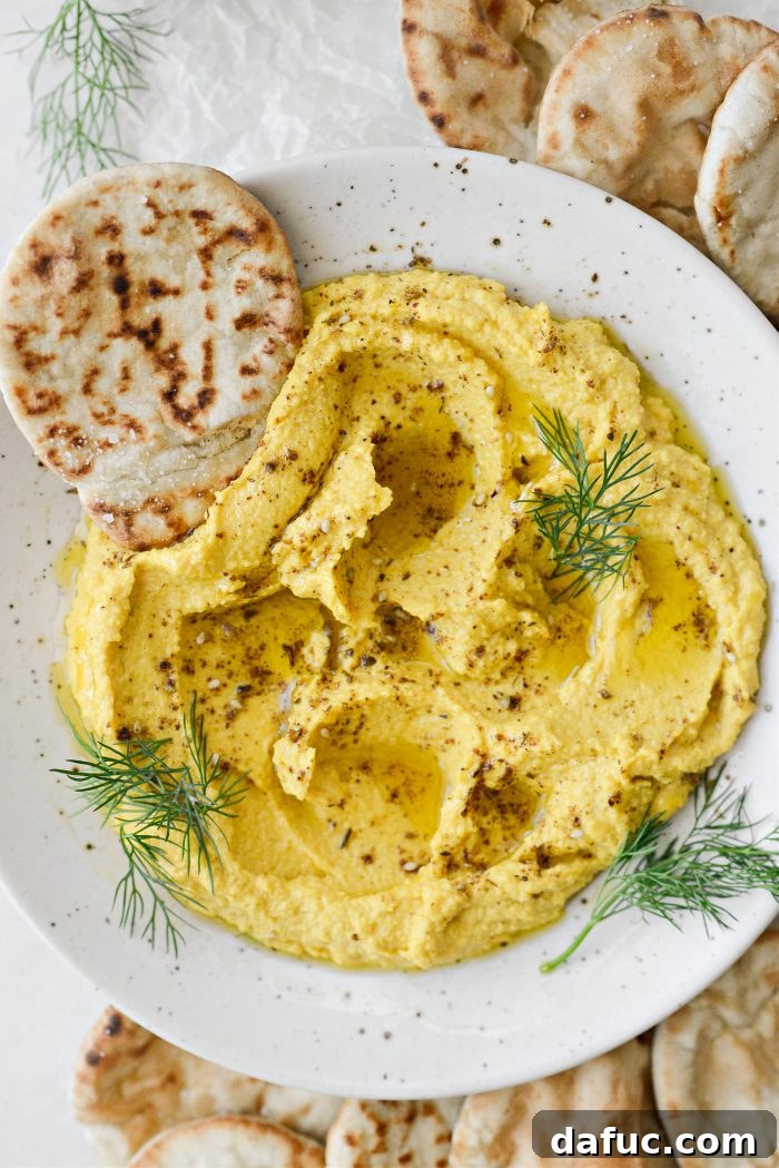 Golden Beet Hummus in a serving bowl, garnished with olive oil and za'atar