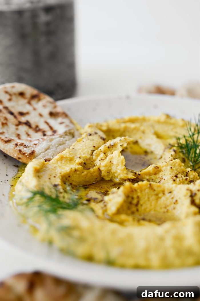 Golden Beet Hummus in a bowl on a white surface, ready to be served