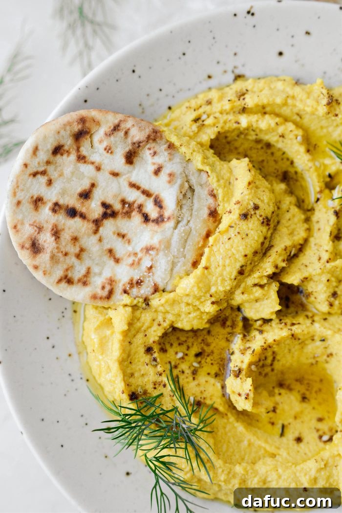 An overhead shot of Golden Beet Hummus served with pita bread and fresh vegetables