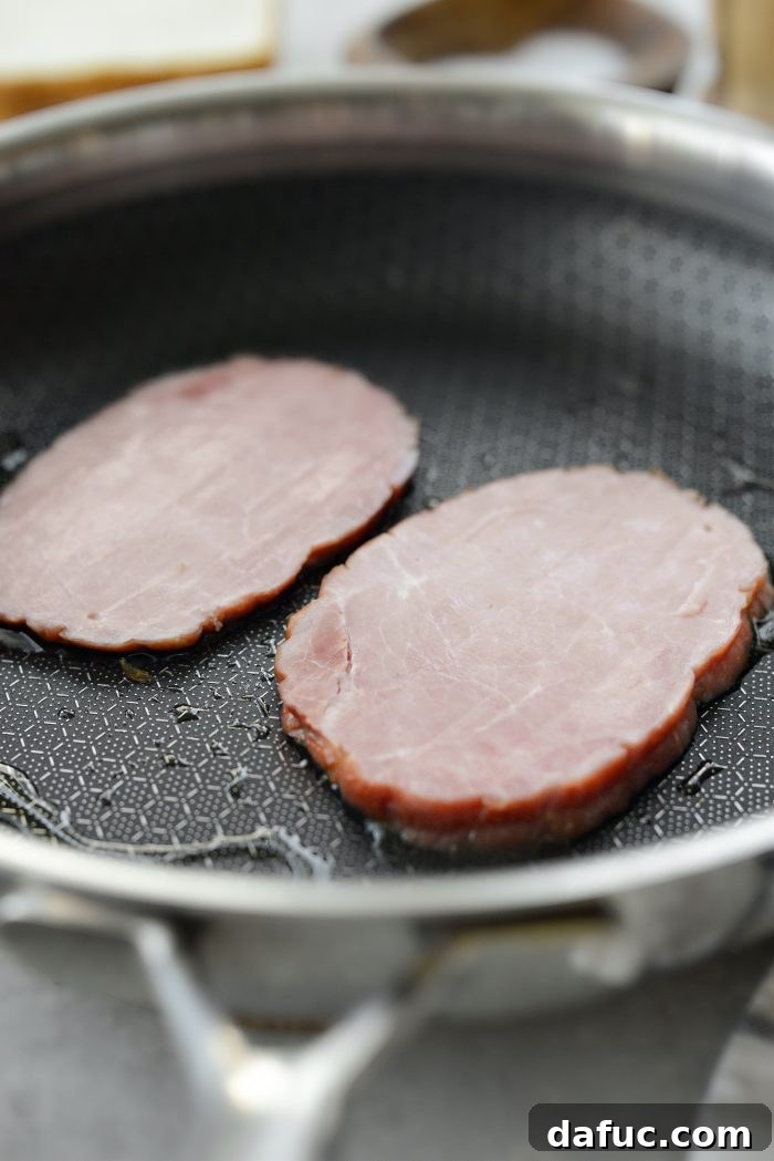 Irish Toast Delight 5 Frying sliced ham in a skillet until golden
