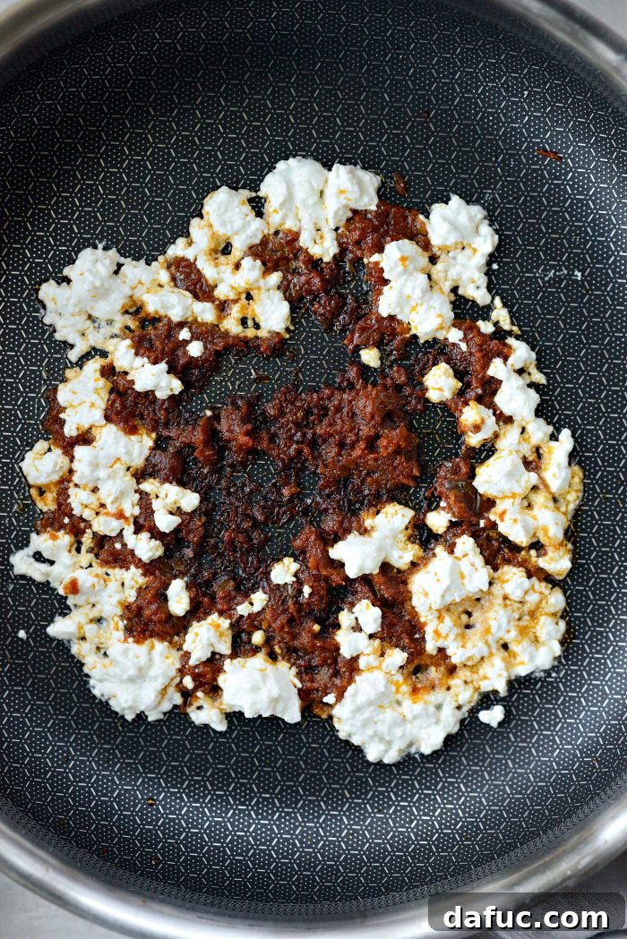 Three Delicious Feta Fried Egg Ideas 5 Melting Feta Cheese and Pesto in a Skillet for Feta Fried Eggs