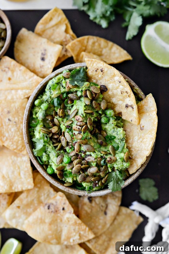 Vibrant Serrano Sweet Pea Guacamole 18 Overhead view of Serrano Sweet Pea Guacamole garnished with spiced pepitas