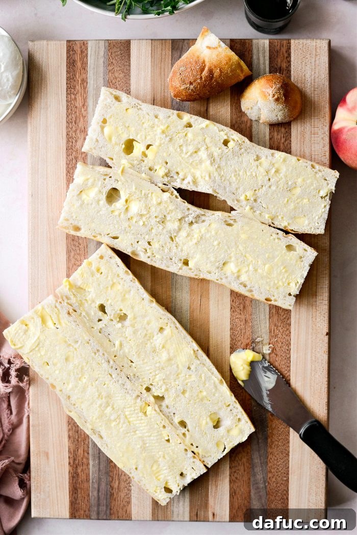 Buttering a sliced baguette for toasting