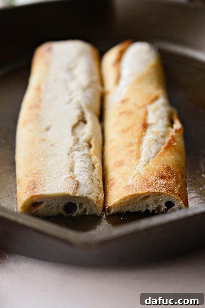 Toasting buttered baguette slices in a skillet until golden