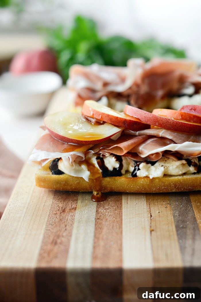 Adding peach slices and hot honey to the sandwich layers