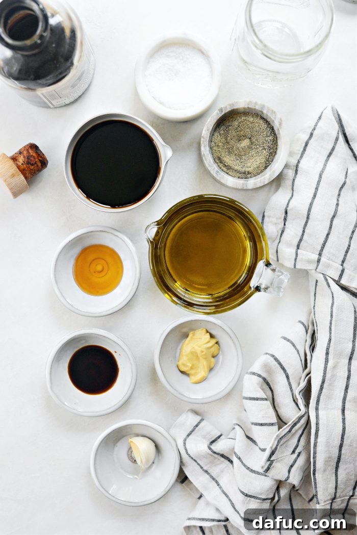 Zesty Honey Balsamic Dijon Vinaigrette 4 Individual ingredients laid out for Balsamic Honey Dijon Vinaigrette preparation, including garlic, Dijon mustard, honey, balsamic vinegar, and olive oil.
