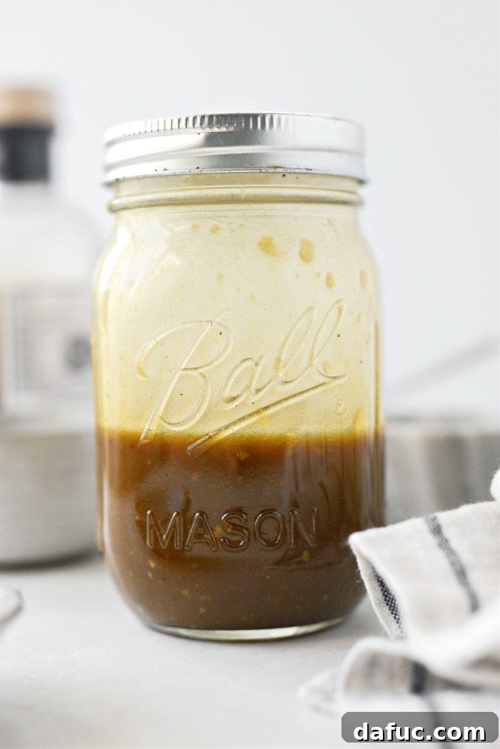 Zesty Honey Balsamic Dijon Vinaigrette 6 A glass jar with Balsamic Honey Dijon Vinaigrette being vigorously shaken to combine all the ingredients.