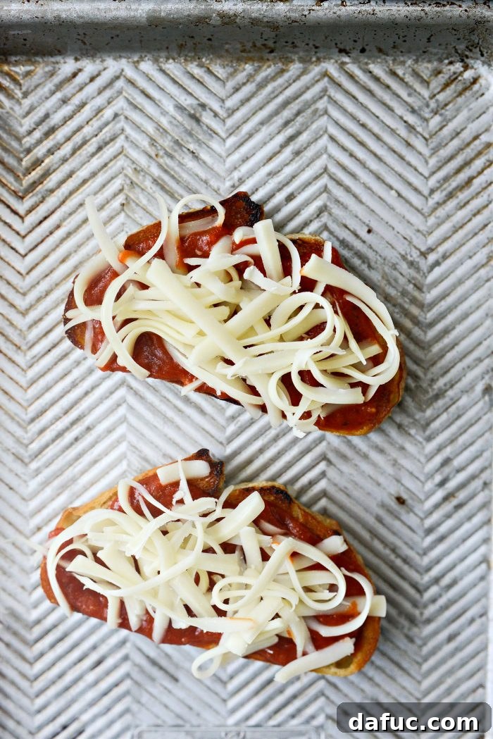 Margherita Toast Pizzas 7 Adding the first layer of mozzarella cheese to the pizza toast