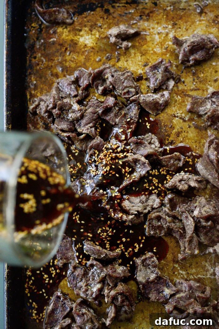 Sheet Pan Steak and Broccoli 11 Pouring the savory sauce over the roasted steak on the sheet pan
