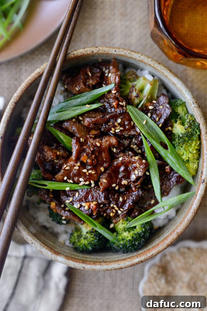 Sheet Pan Steak and Broccoli 15 Sheet Pan Beef and Broccoli served in bowls over rice, garnished with green onions and sesame seeds