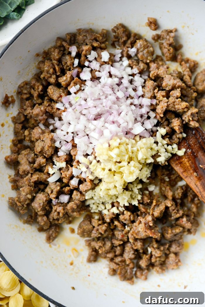 Add diced shallot and minced garlic to the pan with browned sausage