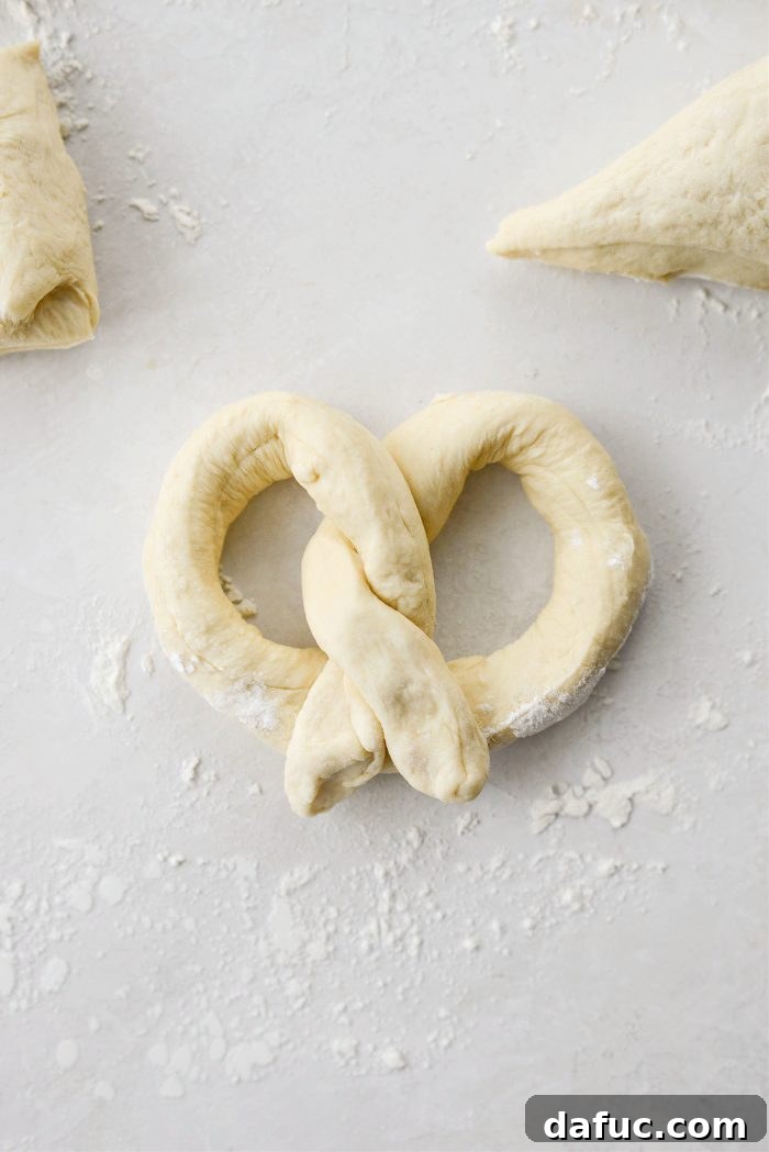 Fold twisted dough over the bottom of the pretzel