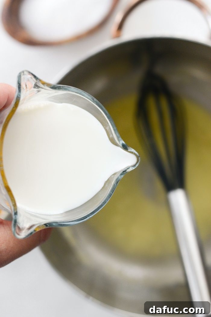 Pour in milk for cheese sauce