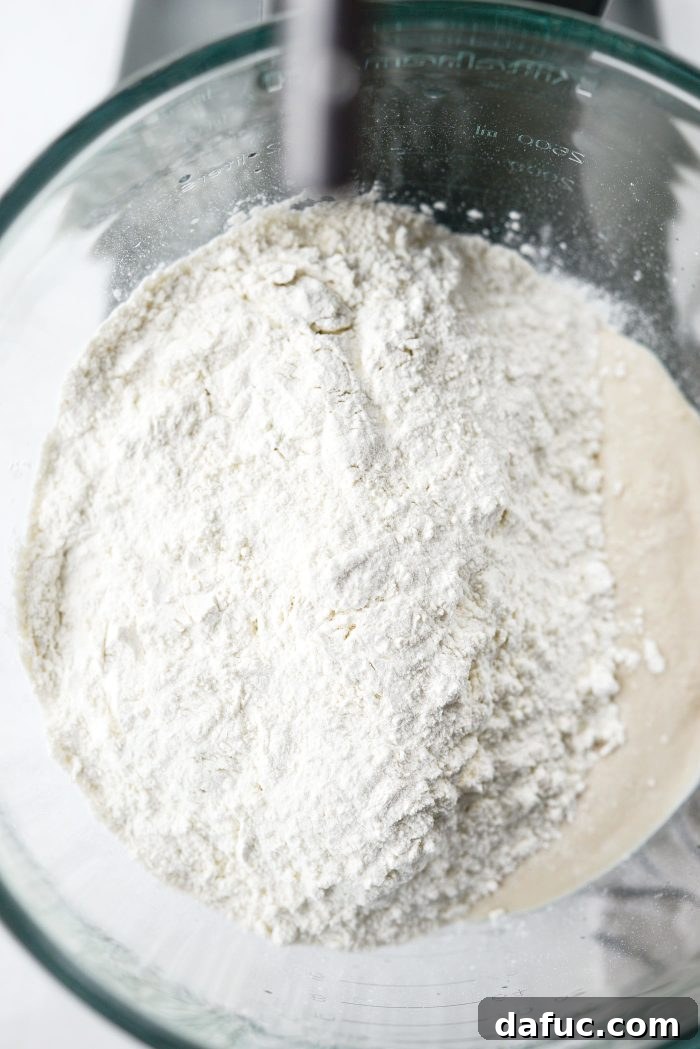Adding flour and salt to yeast mixture