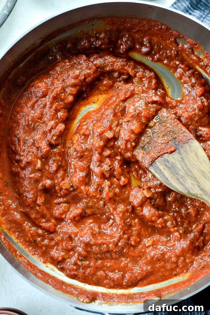 Perfect Homemade Pizza Sauce 14 A close-up shot of the thick, rich homemade pizza sauce bubbling gently in the skillet, showing its perfect consistency.