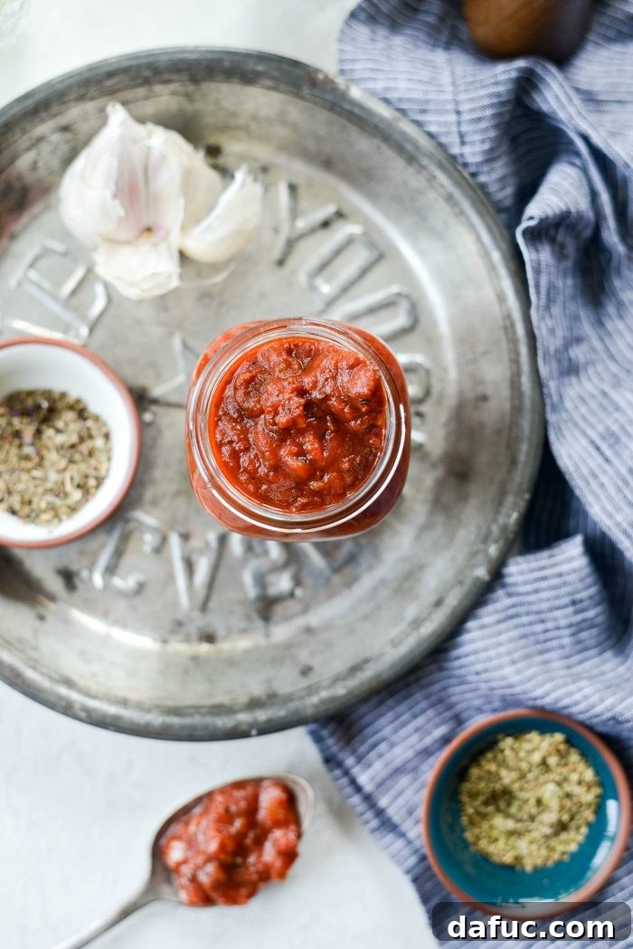 Perfect Homemade Pizza Sauce 15 A beautifully textured homemade pizza sauce spread generously on a pizza crust, with melting cheese and vibrant toppings, ready for baking.