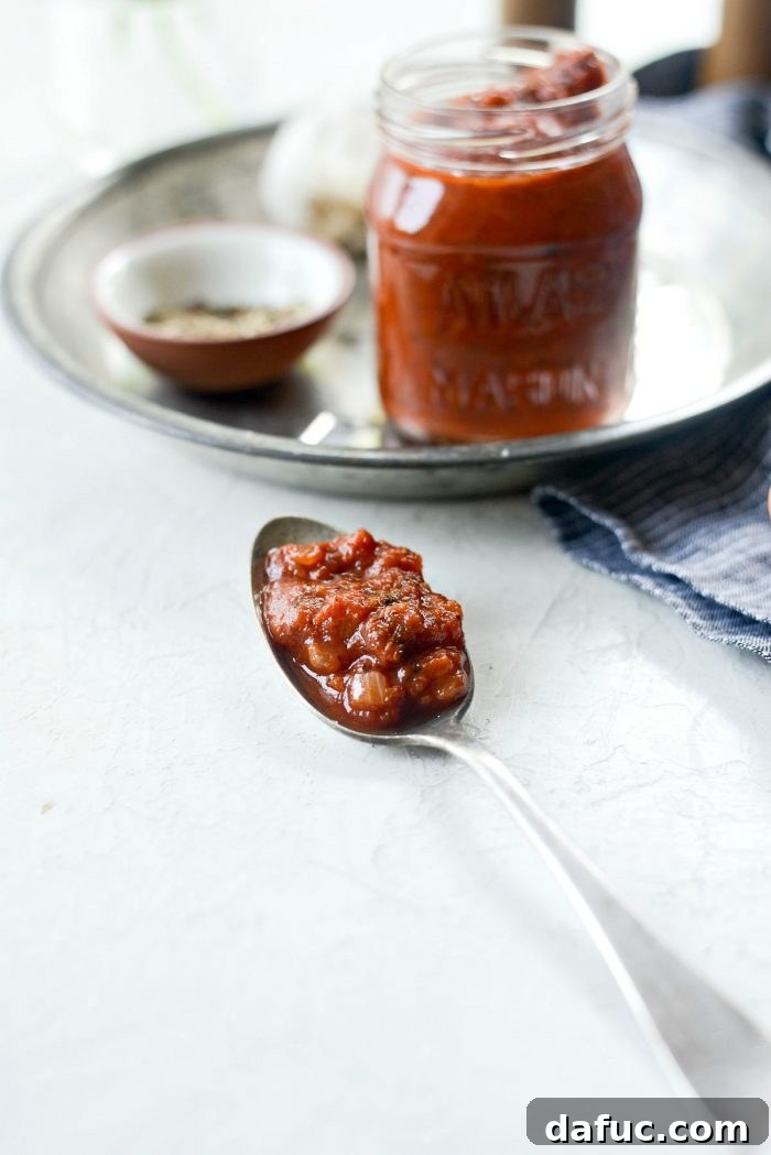 Perfect Homemade Pizza Sauce 16 A spoon full of thick, rich homemade pizza sauce, showcasing its vibrant color and smooth consistency.
