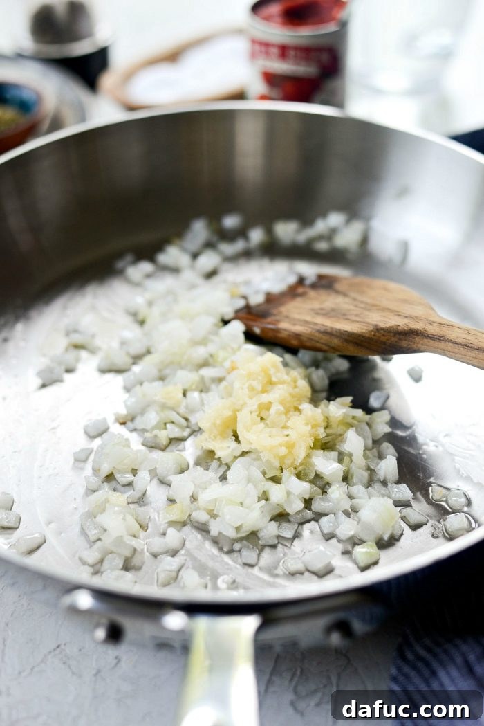 Perfect Homemade Pizza Sauce 6 Freshly minced garlic added to softened onions in a skillet, about to be sautéed for flavor.