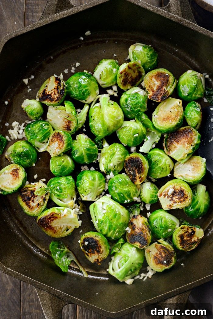 Brussels sprouts being tossed with garlic in a skillet before being transferred to the oven