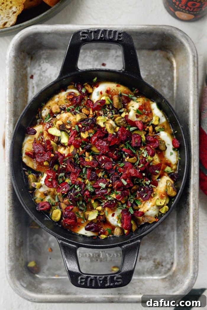 Chili Honeyed Chèvre Indulgence 11 Topping the warm Hot Honey Goat Cheese Dip with black pepper, chopped pistachios, cranberries, and fresh rosemary.