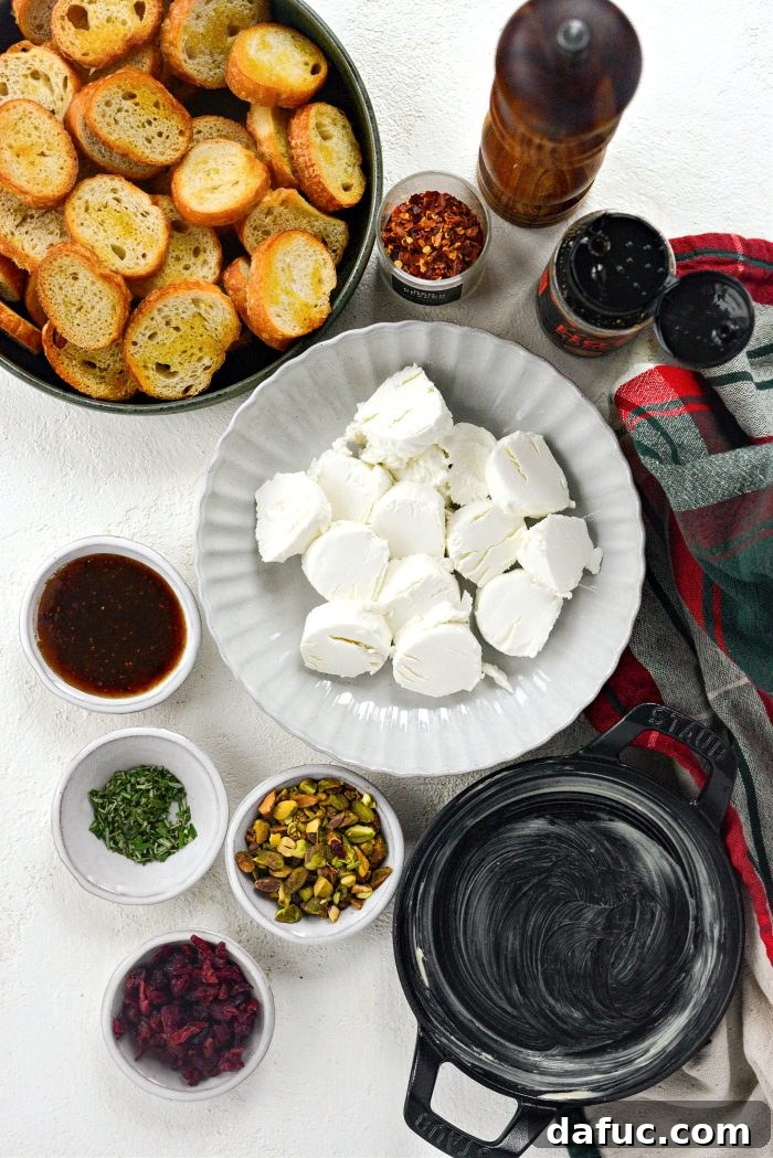 Chili Honeyed Chèvre Indulgence 4 Ingredients laid out for Hot Honey Goat Cheese Dip, including goat cheese, fig jam, honey, pistachios, cranberries, and rosemary.